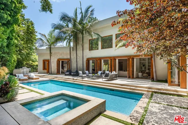 a view of house with swimming pool and sitting area
