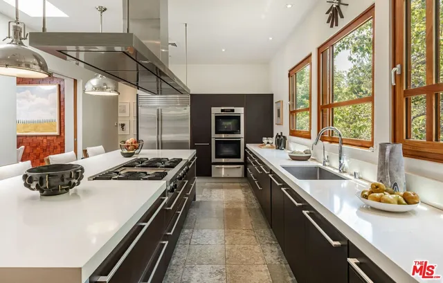 a kitchen with stainless steel appliances a sink stove and cabinets