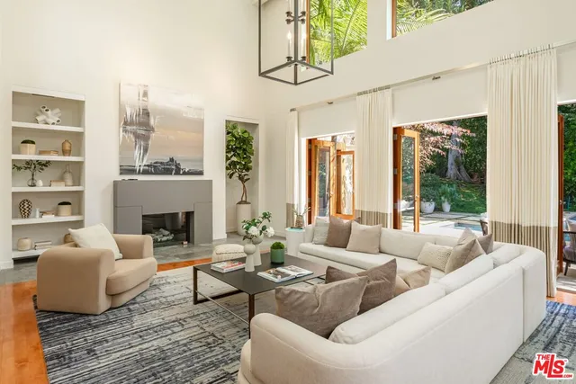 a living room with furniture fireplace and a large window