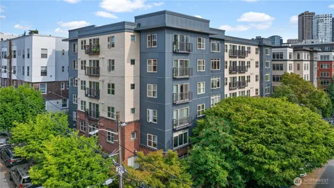 a front view of a multi story building with a yard