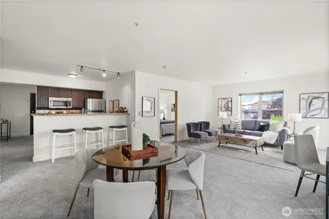 a living room with stainless steel appliances kitchen island furniture and view of kitchen