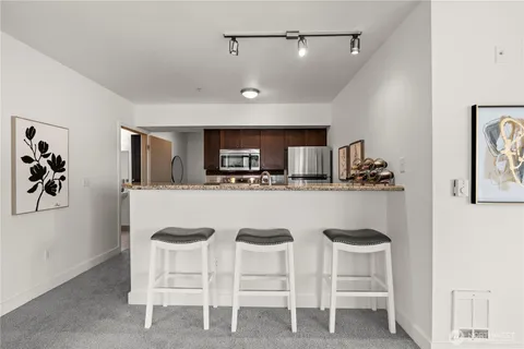 a kitchen with white cabinets and chairs