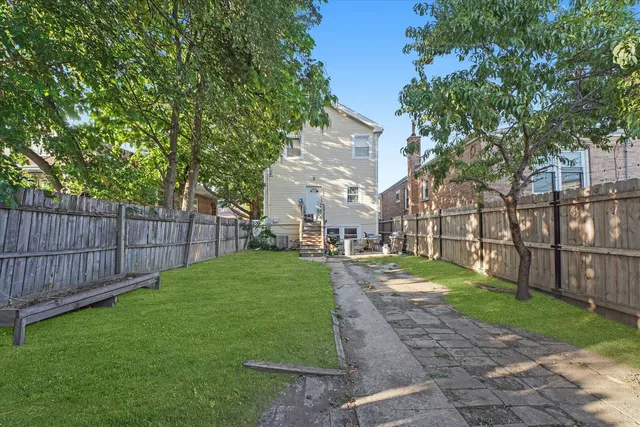 a view of a backyard with wooden fence