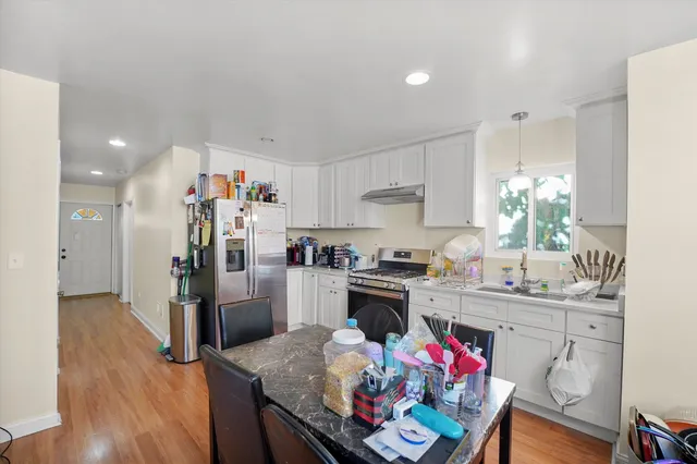 a kitchen with stainless steel appliances granite countertop a refrigerator and a stove top oven