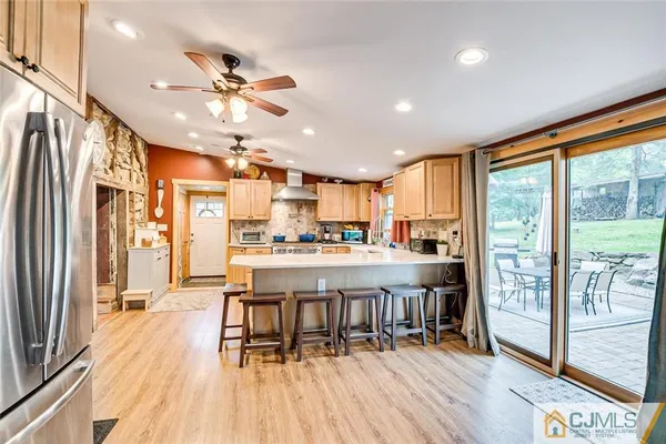a living room with stainless steel appliances granite countertop furniture wooden floor and a large window