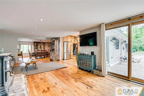 a living room with furniture a flat screen tv and a floor to ceiling window
