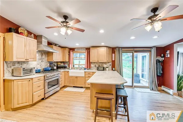 a large kitchen with granite countertop lots of counter top space and stainless steel appliances