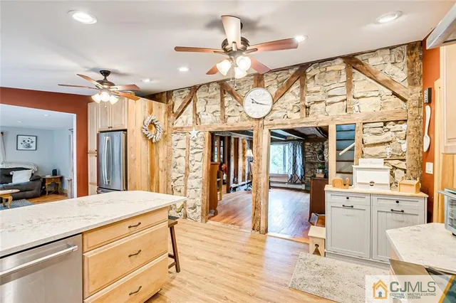 a living room with stainless steel appliances kitchen island granite countertop furniture and a chandelier