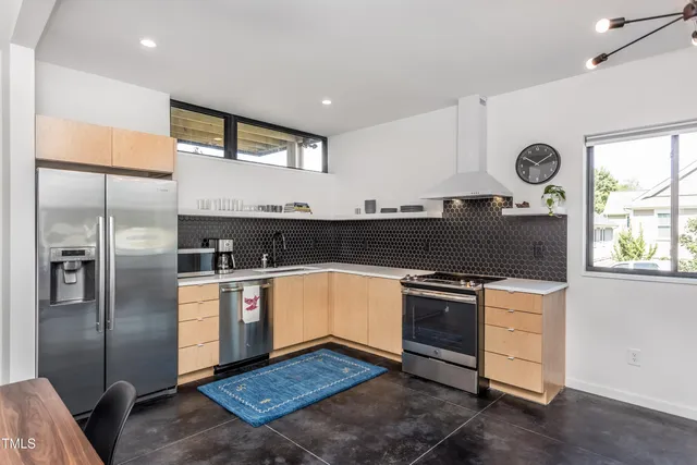 a kitchen with stainless steel appliances granite countertop a stove a refrigerator and a sink