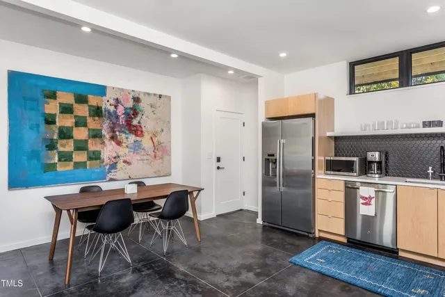 a kitchen with stainless steel appliances kitchen island granite countertop a refrigerator and a stove top oven