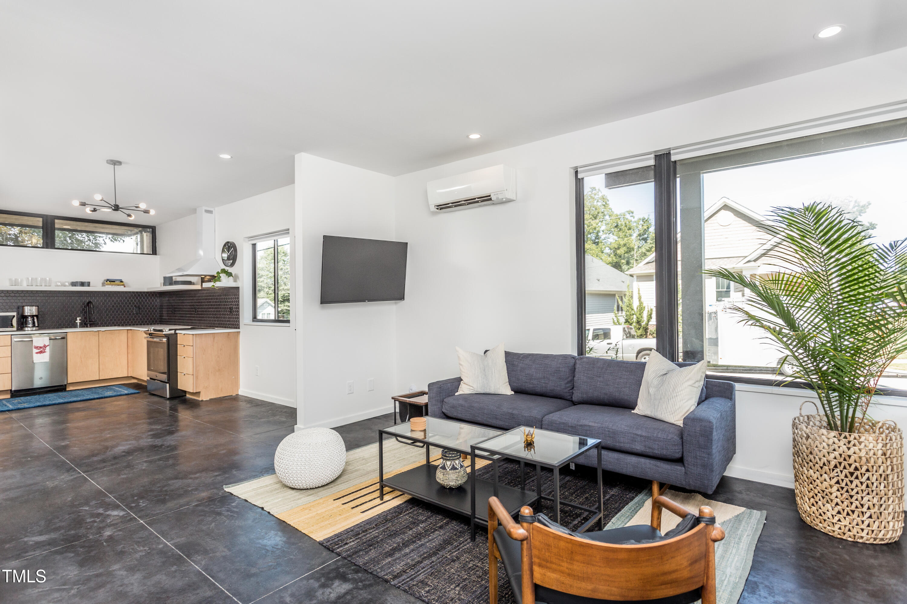 123 Idlewild Avenue, Unit 101 Raleigh, NC 27601 - Photo 19 of 27 a living room with furniture a flat screen tv and a large window