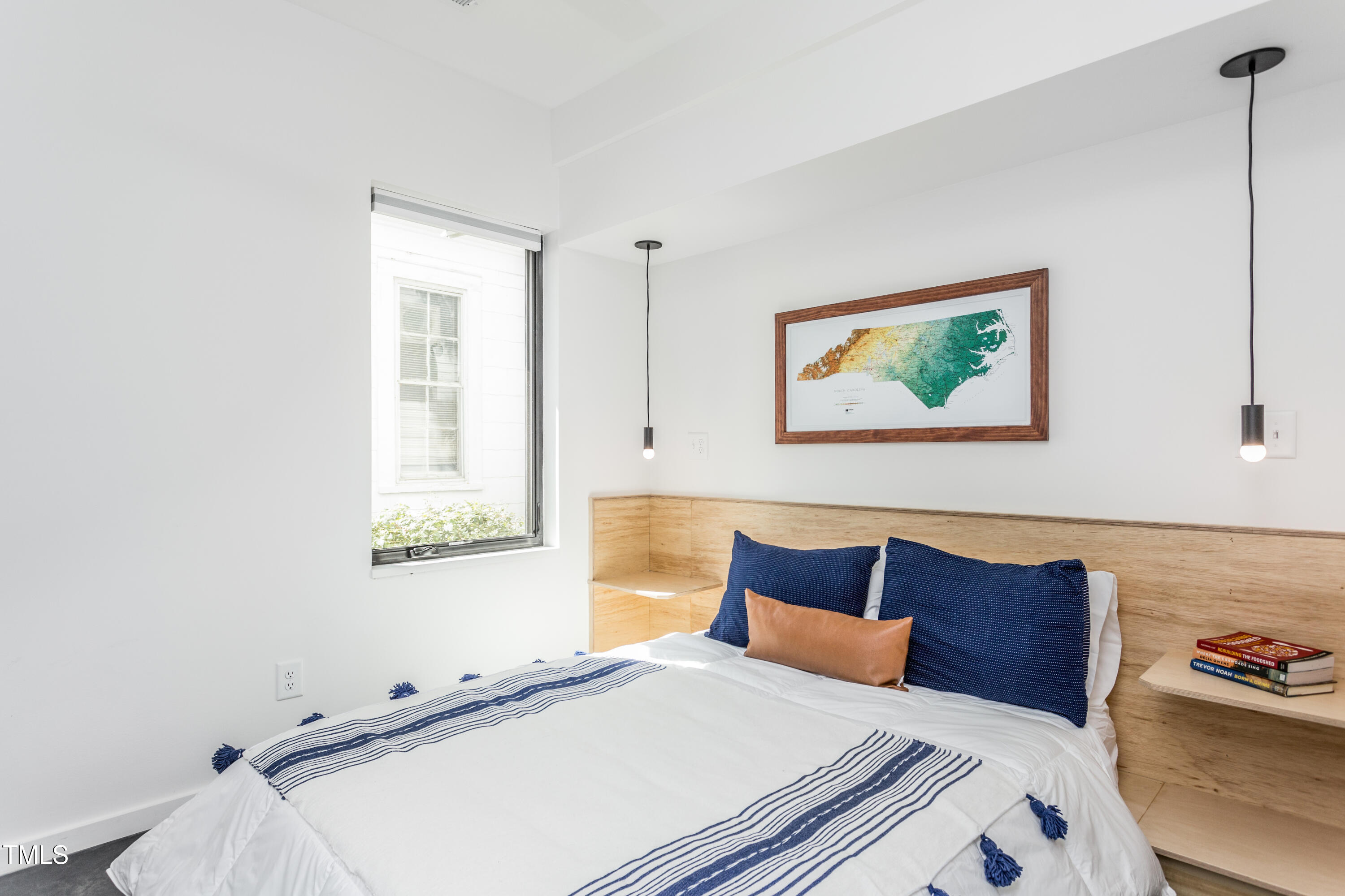 123 Idlewild Avenue, Unit 101 Raleigh, NC 27601 - Photo 22 of 27 a bedroom with a bed and wooden floor