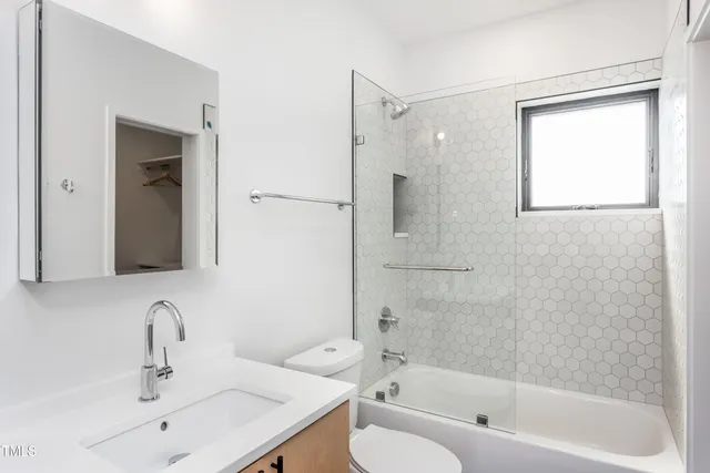 a bathroom with a bathtub shower sink and mirror