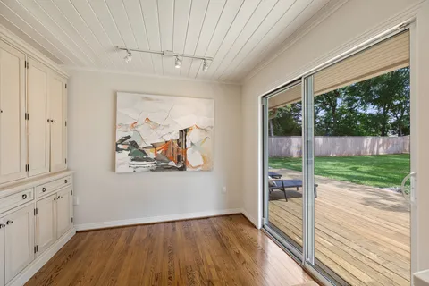 a living room with furniture a rug a fireplace and a large window