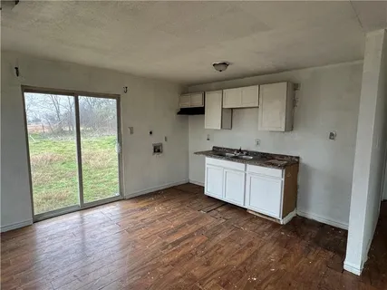 a kitchen with wooden floors and white cabinets
