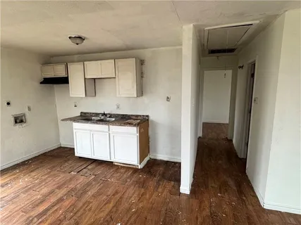 a kitchen with wooden floors and white cabinets