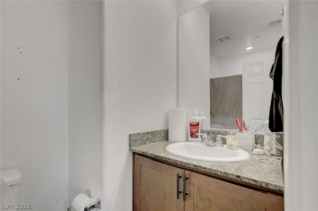 1285 Raritan Place Henderson, NV 89002 - Photo 18 of 20 A classic stone vanity counter sits adjacent to the sleek bathroom wall.