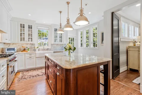 a kitchen with a stove a kitchen island with cabinets and wooden floor