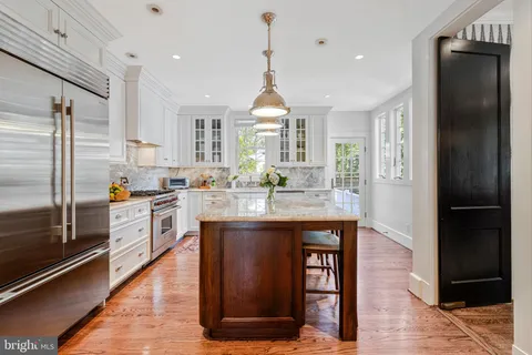 a view of a dining room with furniture a chandelier and wooden floor