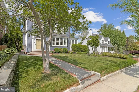a front view of a house with a yard and potted plants