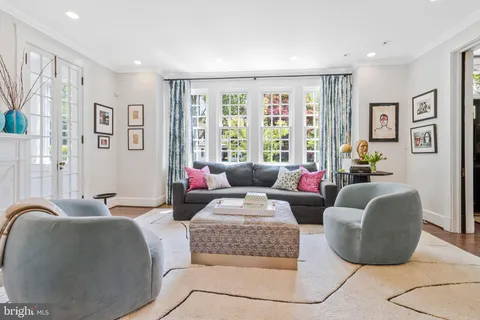 a living room with furniture fireplace and a large window