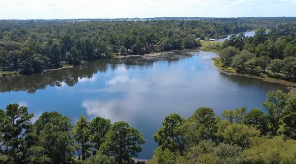 an aerial view of a house with a yard and lake view