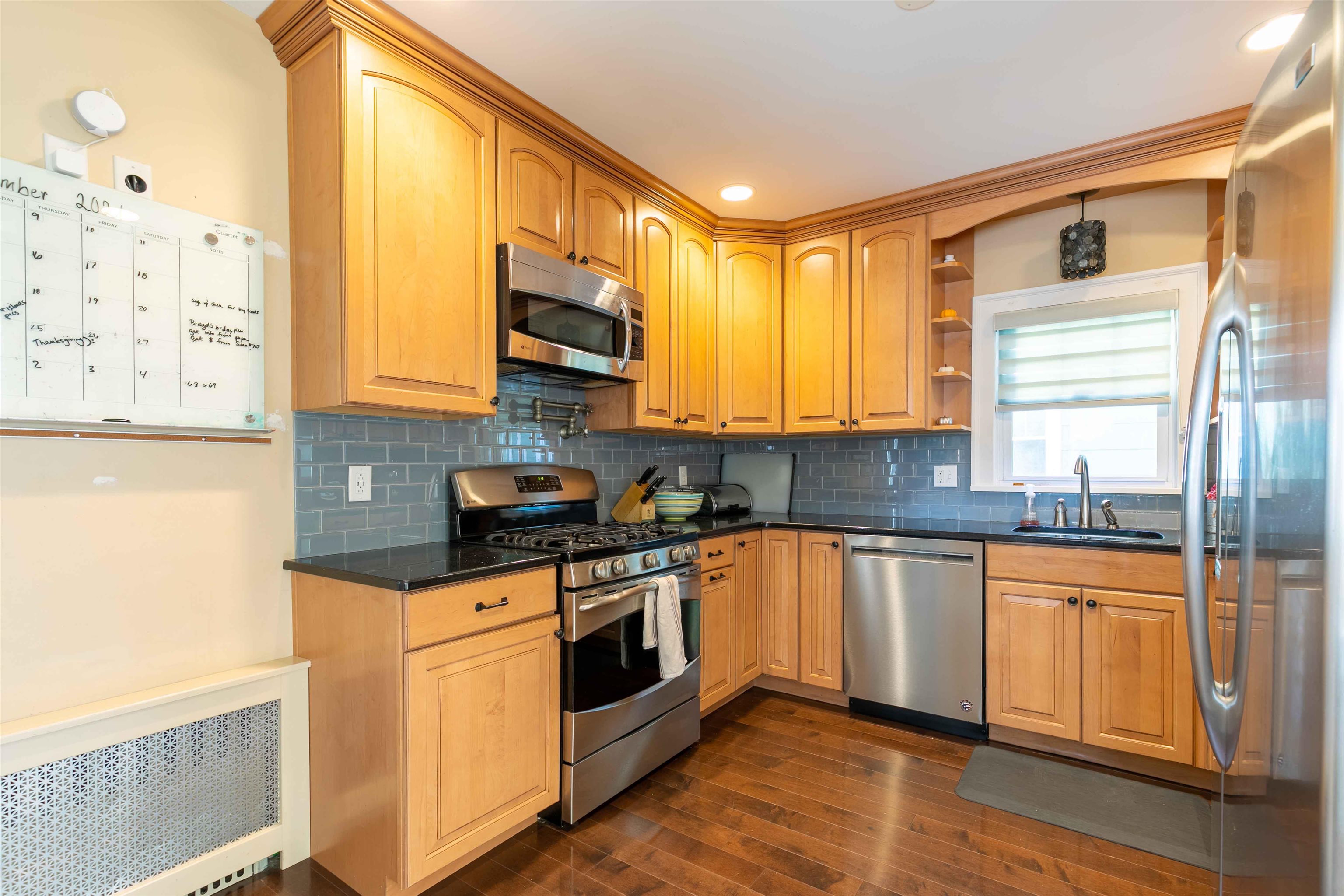 78 Jackson Avenue Rutherford, NJ 07070 - Photo 12 of 36 a kitchen with stainless steel appliances granite countertop a stove a sink and white cabinets with wooden floor
