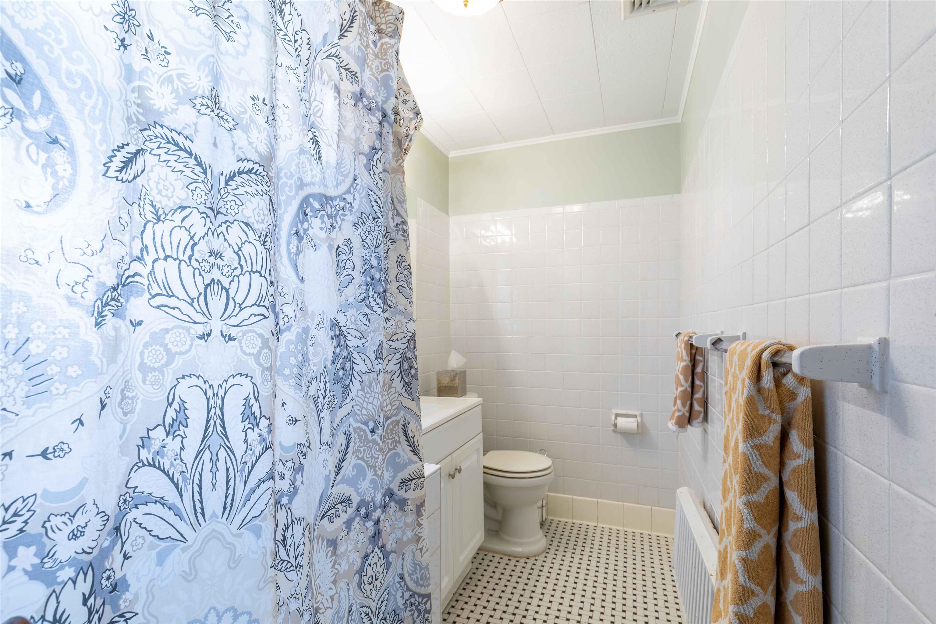 78 Jackson Avenue Rutherford, NJ 07070 - Photo 26 of 36 a bathroom with a toilet and a shower curtain