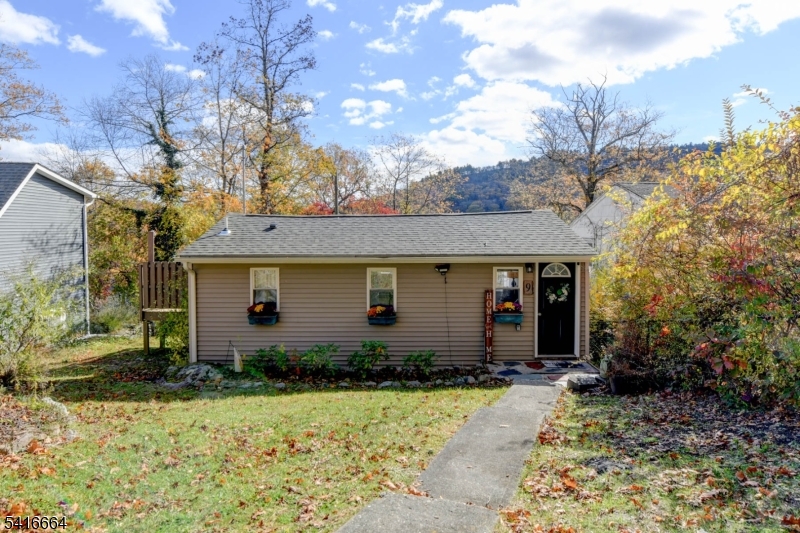 a front view of house with yard and trees around