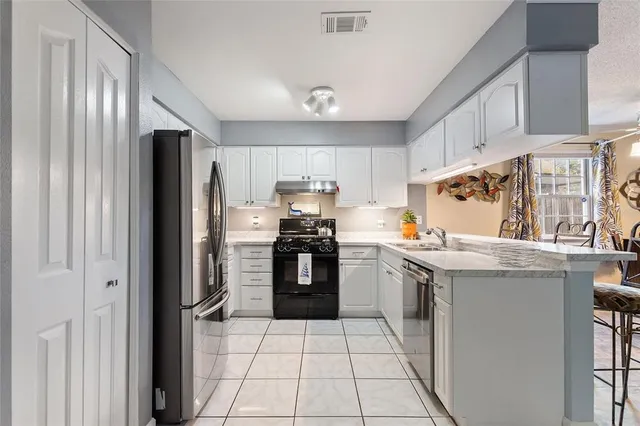 a kitchen with stainless steel appliances granite countertop a refrigerator stove and sink