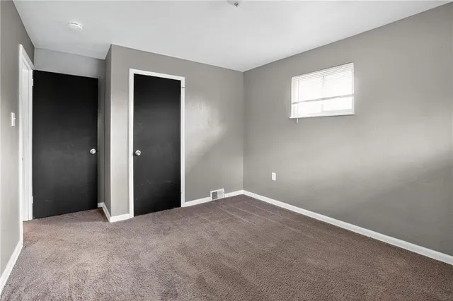 an empty room with windows and closet