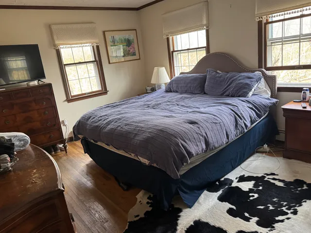a bedroom with a bed mirror and window