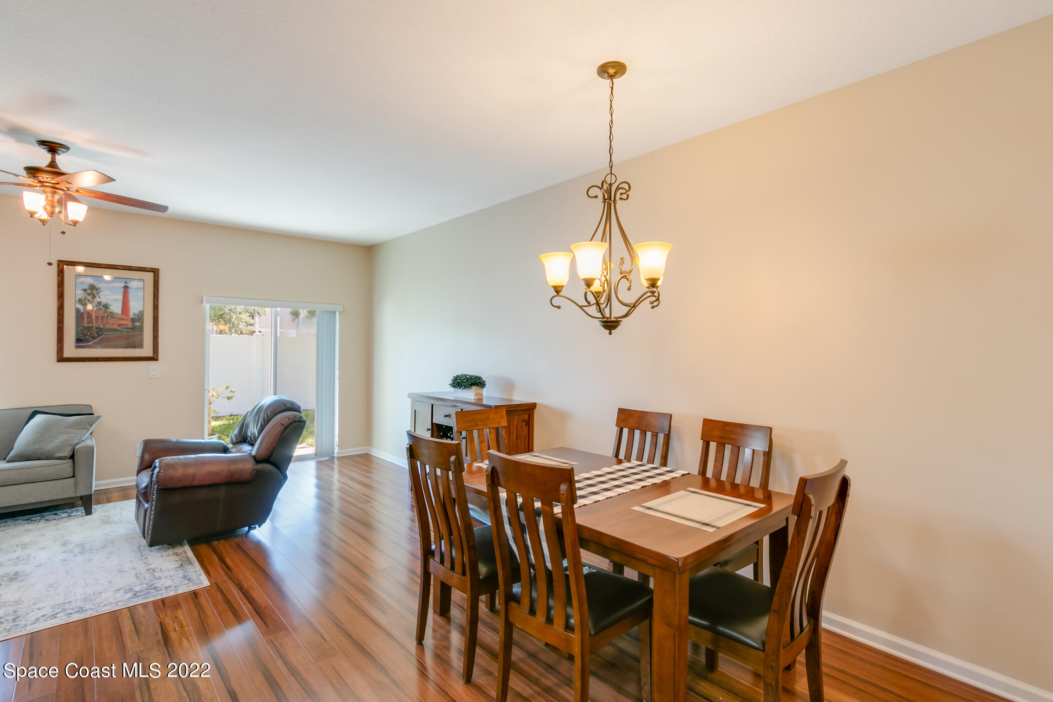 2525 Revolution Street, Unit 104 Melbourne, FL 32935 - Photo 15 of 37 a view of a dining room with furniture wooden floor and chandelier