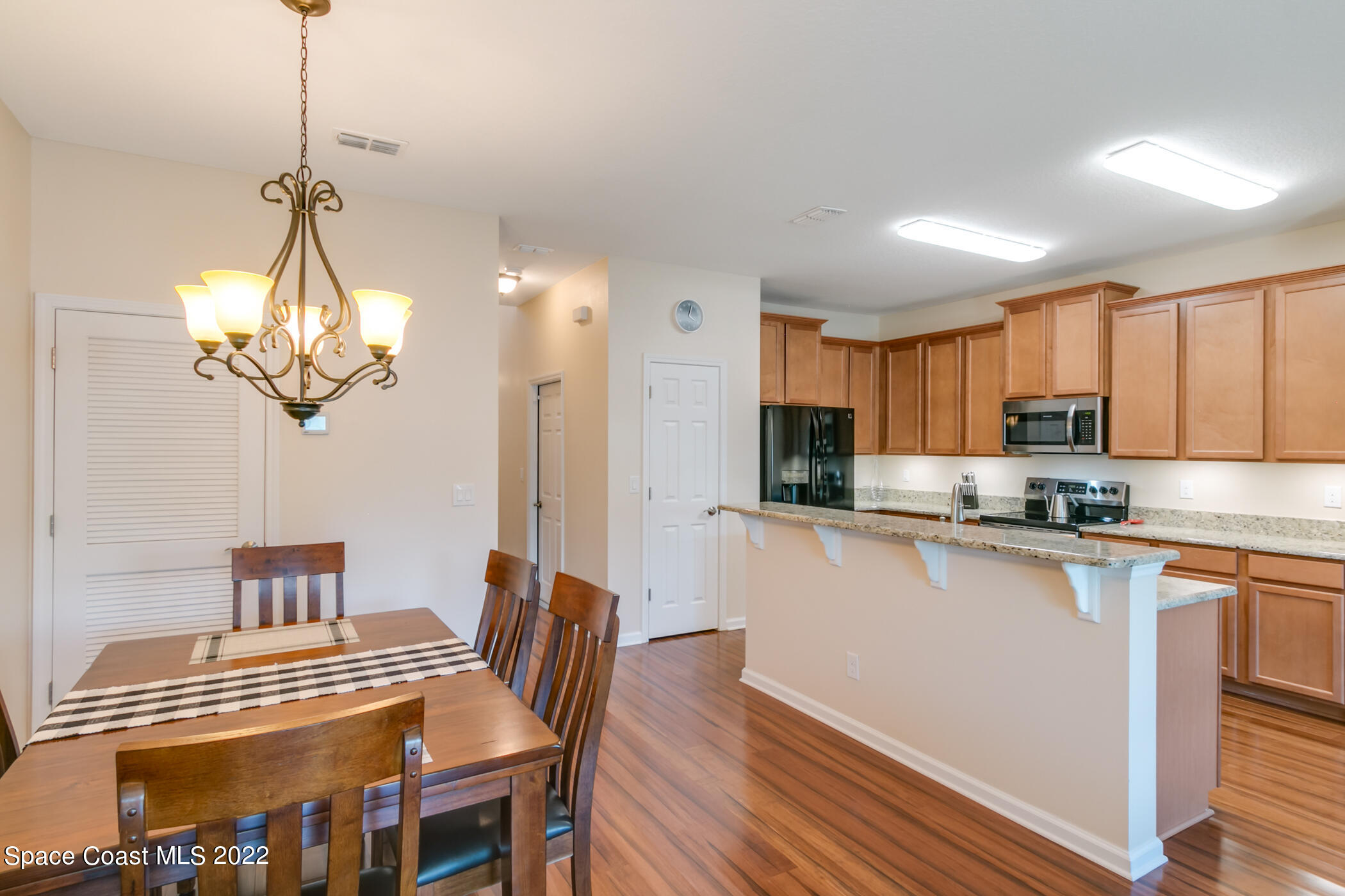2525 Revolution Street, Unit 104 Melbourne, FL 32935 - Photo 20 of 37 a kitchen with stainless steel appliances granite countertop a sink dishwasher a stove a refrigerator with a dining table and chairs