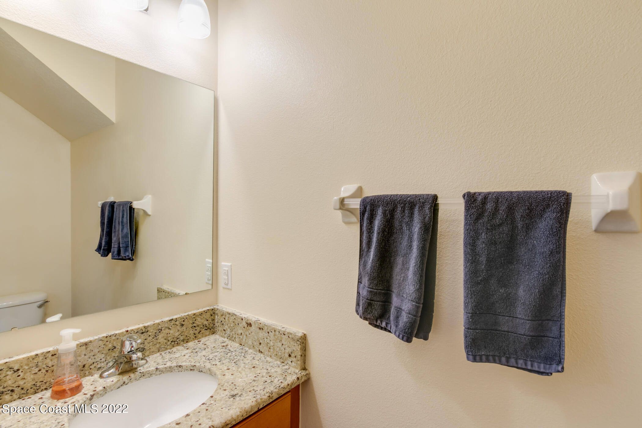 2525 Revolution Street, Unit 104 Melbourne, FL 32935 - Photo 26 of 37 a bathroom with a granite countertop sink and a mirror