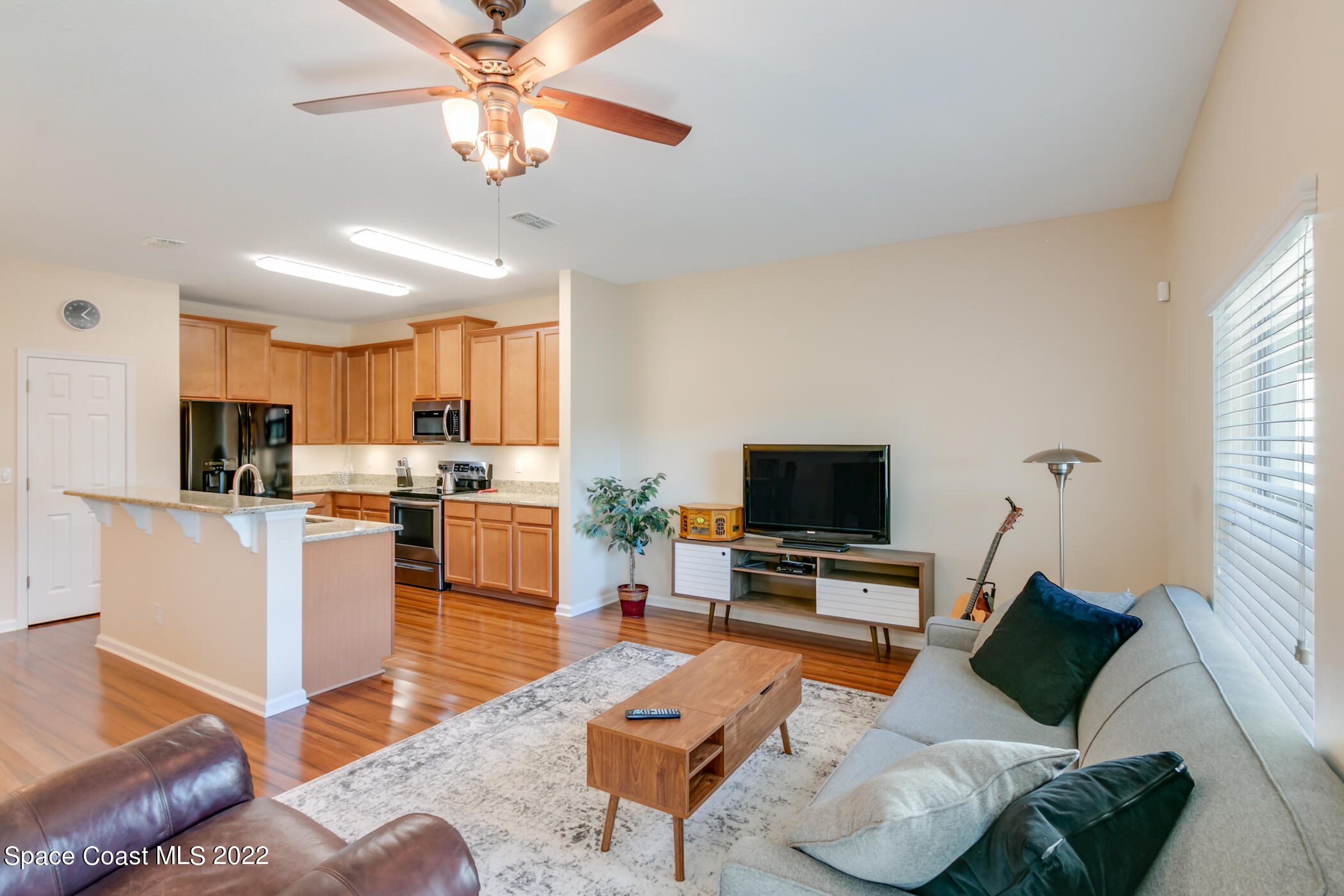 2525 Revolution Street, Unit 104 Melbourne, FL 32935 - Photo 32 of 37 a living room with furniture kitchen view and a flat screen tv