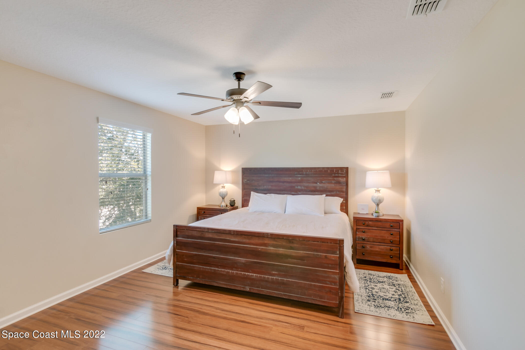 2525 Revolution Street, Unit 104 Melbourne, FL 32935 - Photo 34 of 37 a bedroom with a bed and a chandelier