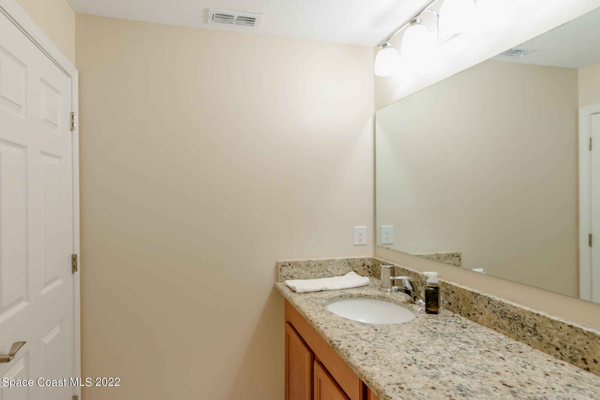 2525 Revolution Street, Unit 104 Melbourne, FL 32935 - Photo 36 of 37 a bathroom with a granite countertop sink and a mirror
