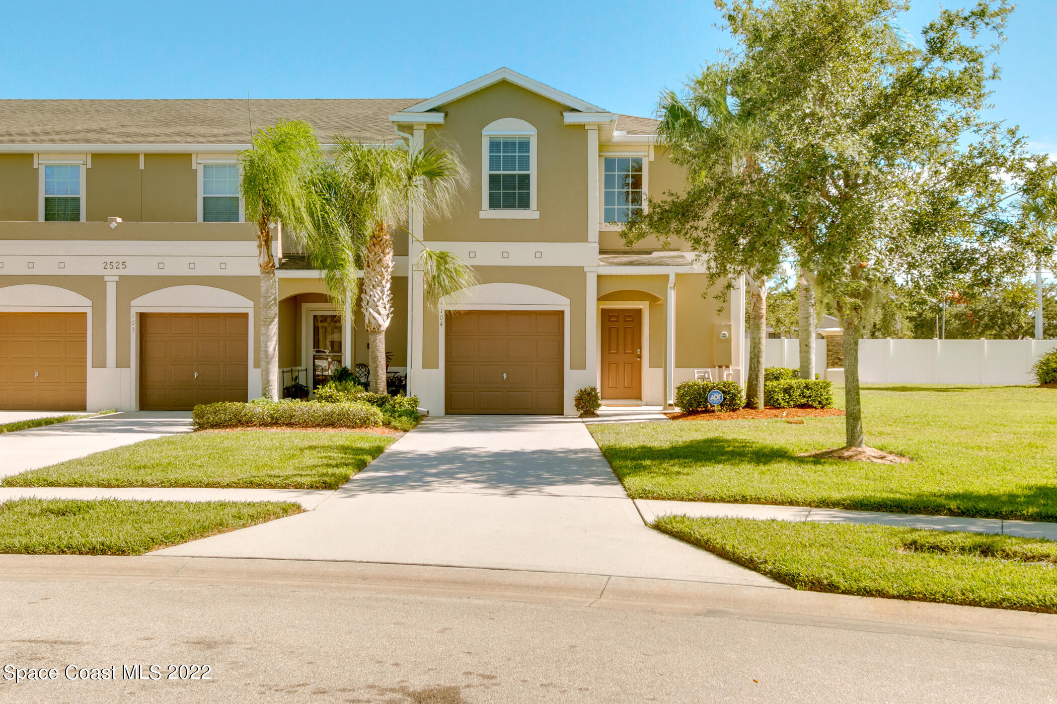 2525 Revolution Street, Unit 104 Melbourne, FL 32935 - Photo 7 of 37 a front view of a house with a yard and garage