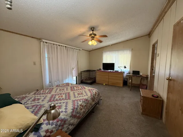 a spacious bedroom with a bed and a chandelier