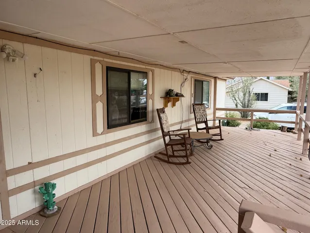 a view of a patio with table and chairs with wooden floor and fence
