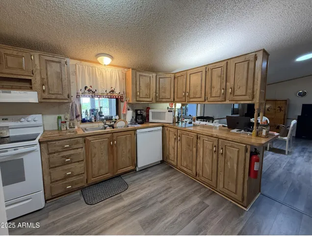 a kitchen with kitchen island granite countertop a sink cabinets and stainless steel appliances
