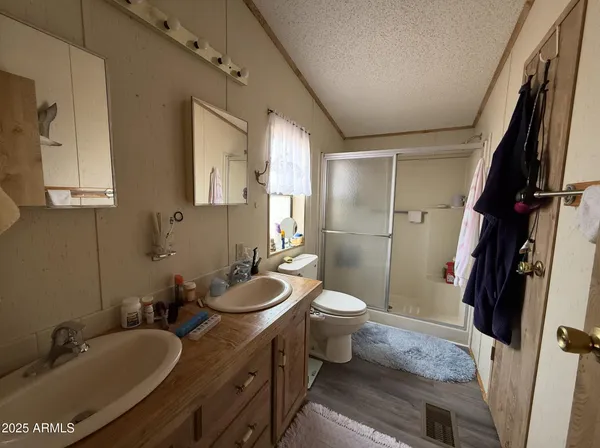 a bathroom with a granite countertop sink toilet a mirror and shower