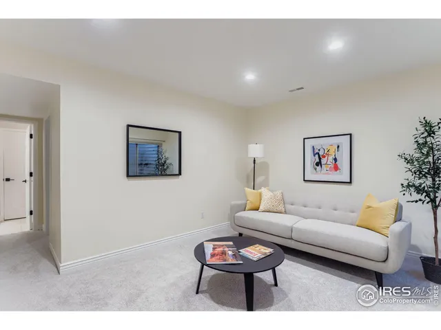 a living room with furniture and a wall painting