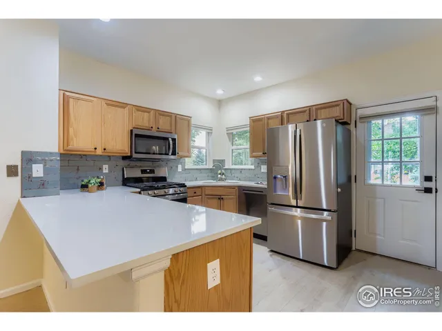 a kitchen with stainless steel appliances a refrigerator a stove a microwave a sink and a refrigerator