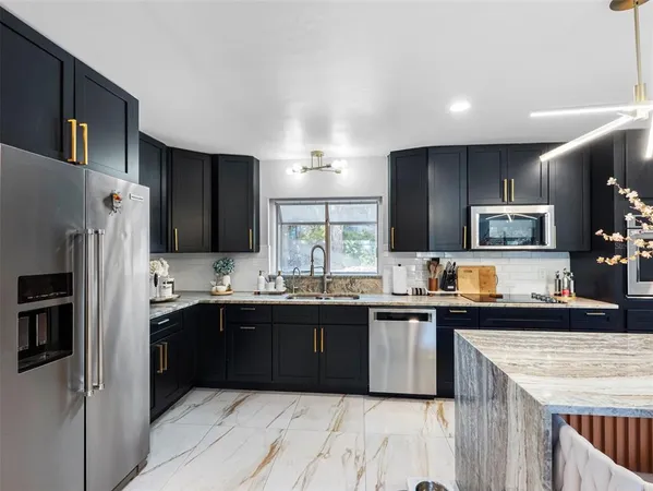 a large white kitchen with a large counter top appliances and cabinets