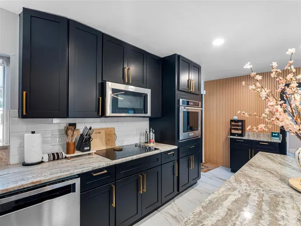 a kitchen with stainless steel appliances kitchen island granite countertop a stove microwave and sink