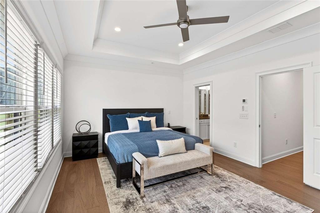 6786 Encore Boulevard Atlanta, GA 30328 - Photo 13 of 31 a bedroom with a bed and wooden floor