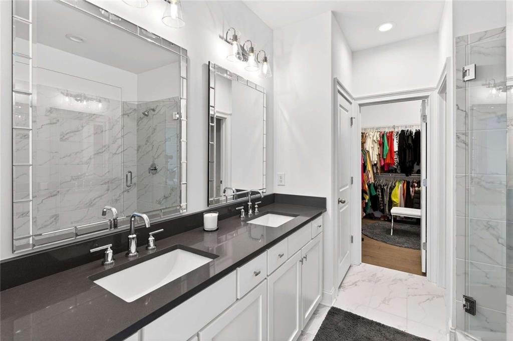 6786 Encore Boulevard Atlanta, GA 30328 - Photo 14 of 31 a bathroom with a sink double vanity granite tub shower and a mirror