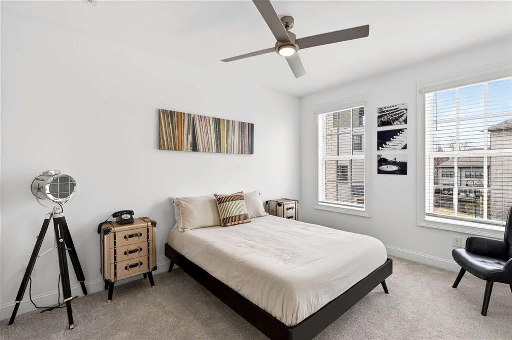 6786 Encore Boulevard Atlanta, GA 30328 - Photo 19 of 31 a bedroom with a bed a dresser and a window